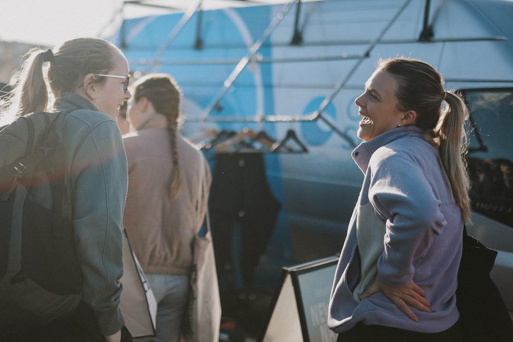 Two newbies laughing together at a surf social