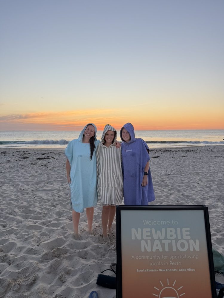 Three newbies in towels at a sunset dip